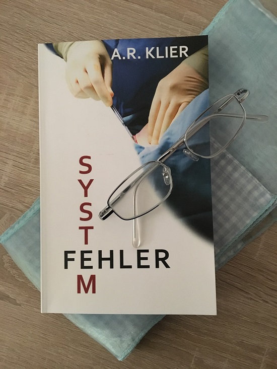Systemfehler von A. R. Klier Taschenbuchcover von oben mit Brille